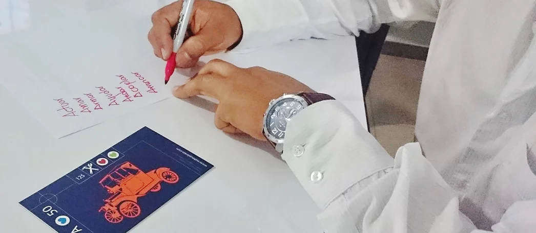 Ejercicio creativo de escritura con WakeUpBrain, donde los participantes diseñan juegos familiares innovadores a partir de verbos y tarjetas visuales que estimulan el pensamiento divergente.