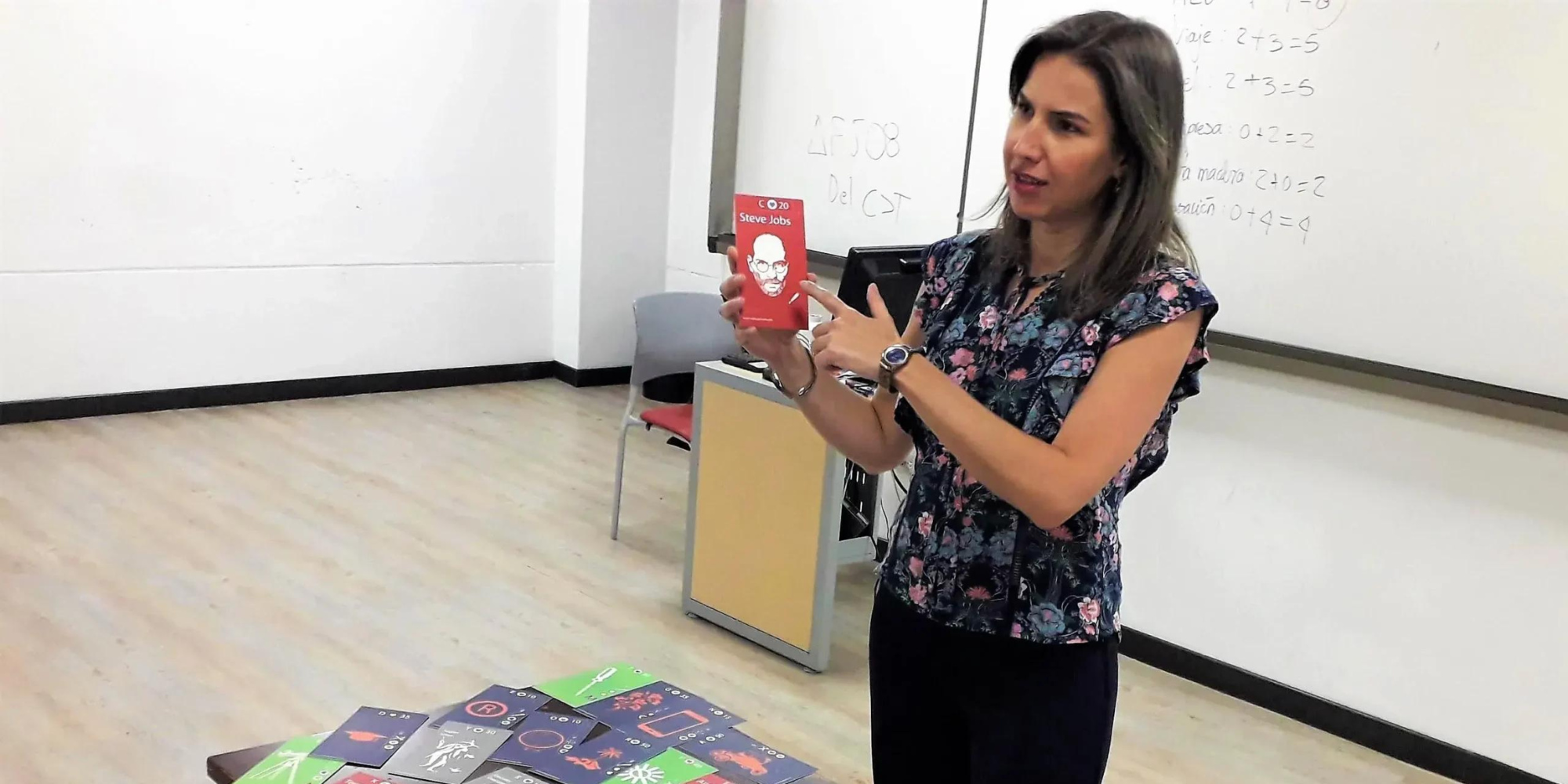Facilitadora señalando una tarjeta de Steve Jobs durante un ejercicio de WakeUpBrain para activar la creatividad y la inspiración empresarial.